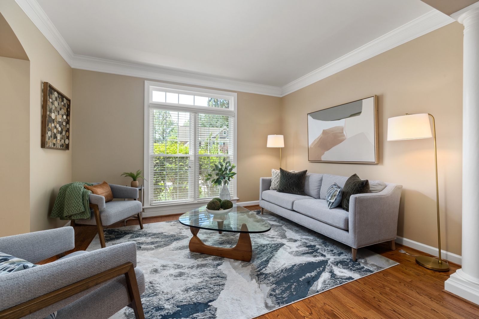 A bright, neutral living room staged for showings